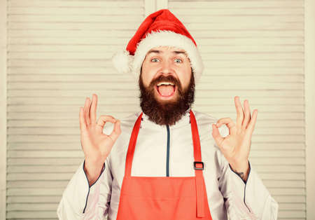 Man santa hat bearded hipster wear culinary apron. Cooking dish for family. Cooking delicious and quick holiday meal. Last minute christmas dinner idea. Simple recipe with little active cooking timeの写真素材