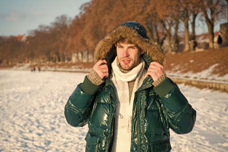 Travel and vacation concept. Winter outfit. Guy jacket hood. Man warm jacket snowy nature...