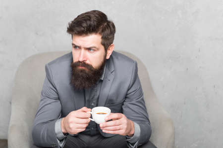 Recharge and reload. Man handsome bearded businessman hold cup of coffee. Coffee break concept. Business people. Best coffee served for him. Attractive pensive manager in thoughtful mood. Coffee cupの写真素材