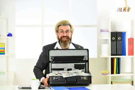 look at that. Businessman hand holding briefcase. suitcase with money. good deal. modern life and business. corporate leather bag. mature man with case at workstation. happiness and successの写真素材