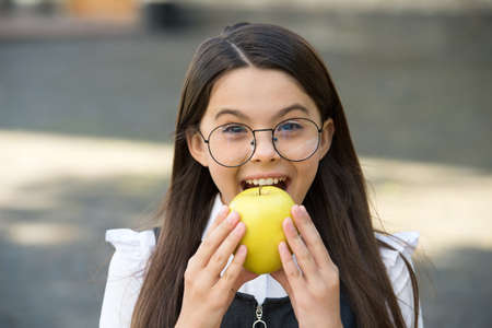 Food for your teeth. Little child bite apple outdoors. School snack. Healthy eating. Patient education. Dental health. Oral hygiene. Cavities and teeth decay prevention. Pediatric dentistryの写真素材