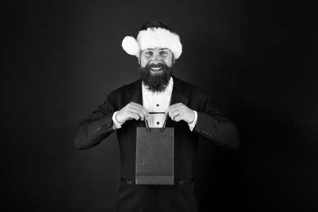 Buy new year gifts. Shopping for presents. Discount for club members. Delivering your purchase. Everything you need to fight winter chill. Shopping with pleasure. Bearded man hold shopping bagの写真素材