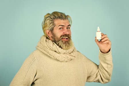 Effective nasal spray. Runny nose and other symptoms of cold. coronavirus from china. man use effective medicines. happy man hold nasal drops. It helps. Flu concept. hipster feels badly ill sneezingの写真素材