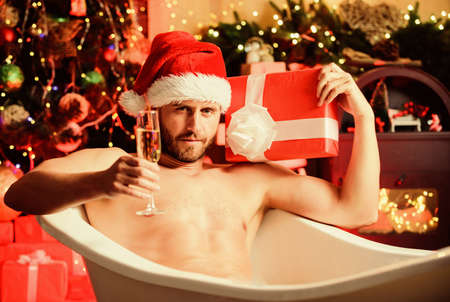 Feeling sexy today. muscular man relax bath. macho drink champagne after party. happy new year gift. erotic wish. feel desire. sexy mature man bath. winter holidays. best xmas present. christmas spaの写真素材