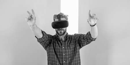 Interaction in virtual reality with digital surface. Man unshaven guy with VR glasses, pink...