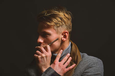 Man in vintage style shaves cheek with razor.の写真素材