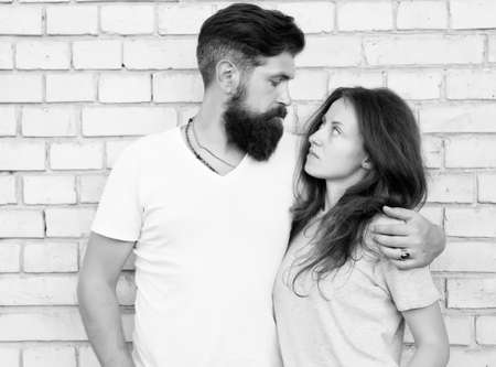 Moments of intimacy. Couple in love. Family couple hugging on brick wall. Loving couple of bearded man and sexy woman. Sensual couple togetherの写真素材