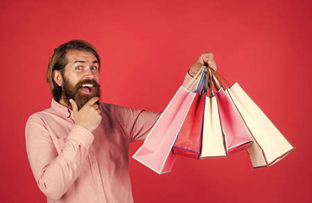 businessman holding gift pack. gift to colleague at work. surprised man unpacking. the package delivery. human emotion and facial expression. bearded man gift holiday decoration. Clothing storeの写真素材