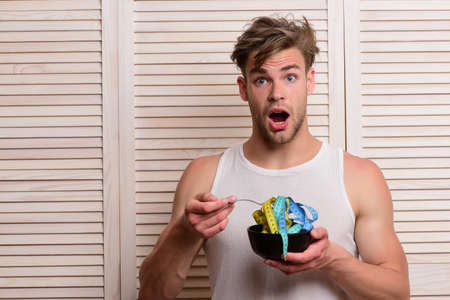 Guy with shocked face expression eating measuring tapeの写真素材
