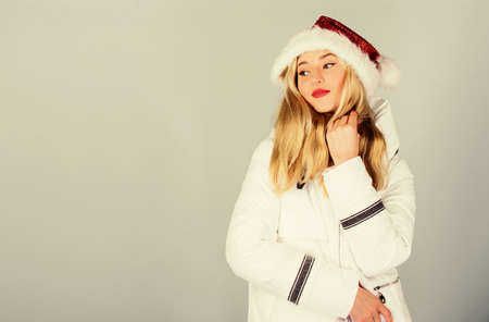 New year new me. warm clothing. fun and gifts. happy new year. merry christmas. morning before xmas. winter holidays and vacation. woman in down jacket. girl santa claus hat. padded coat fashionの写真素材