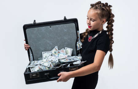 stylish girl with retro look has money cash dollar in suitcase isolated on white, luxuryの写真素材