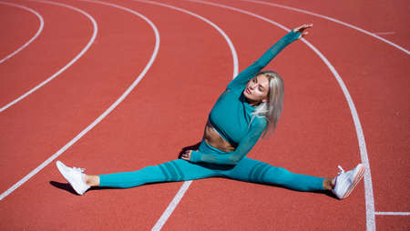 Keeping those muscles flexible. sexy fitness woman in sportswear. athletic lady stretching. female athlete ready for sport workout. trainer or coach training. perfect body shape. healthy and sportyの写真素材
