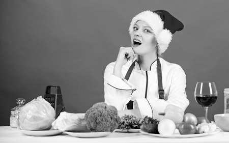 Healthy christmas holiday recipes. Easy ideas for christmas party. Woman chef santa hat cooking at kitchen. Best christmas recipes of perfect housewife. Christmas dinner idea. Cooking for familyの写真素材