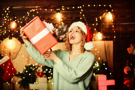 Christmas party time. winter holidays and vacation. Christmas shopping. girl in santa hat present box. cheerful woman share xmas gift. merry christmas. happy new year. Celebrating xmas with familyの写真素材