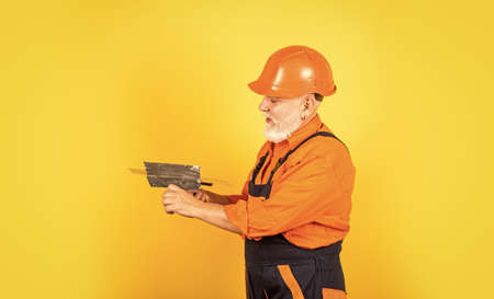 He needs little break. Plasterer in working uniform plastering. man with spatula. process of...