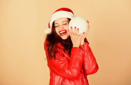 Santa girl. Fashion trend. Winter season of contrasts. Accessory for celebration. Christmas mood. Winter clothes. Woman wear down jacket. Warm and cozy. Girl wear winter jacket beige backgroundの写真素材