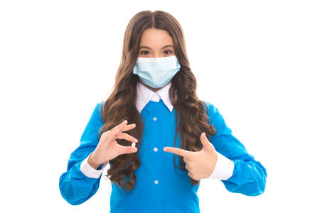 healthcare during covid pandemic. vitamins and antipyretic. girl pointing finger on pill. coronavirus treatment. kid in drug store. follow doctor prescription. child in medical mask hold antibioticsの写真素材