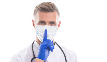 medical worker man physician in respirator mask and rubber gloves with phonendoscope show hush gesture for keeping quiet coronavirus department, covid19の写真素材