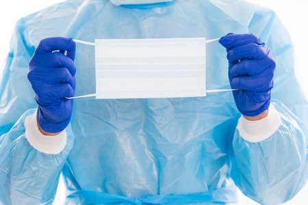 respirator medical mask for protection in doctor hands with surgical gloves and safety costume against coronavirus pandemic outbreak, covid virus.の写真素材