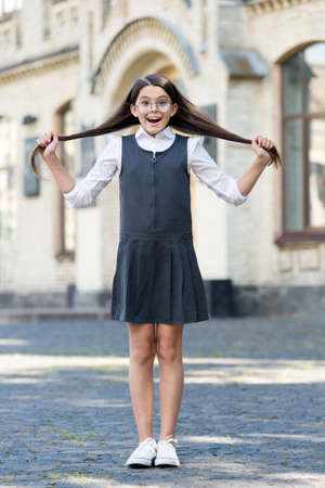 Let it grow. Happy child hold long hair outdoors. Back to school look. Hair salon. Hairdressing education. Haircare and scalp beautyの写真素材