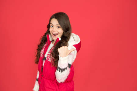 warm clothes at wintertime season. cold weather forecast. kid fashion and shopping. xmas time. ready for new year vacation. copy space. no hypothermia. cheerful girl wearing layers of clothingの写真素材