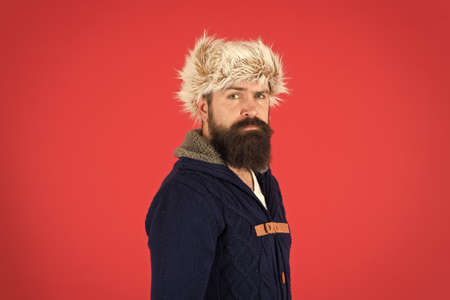 Posing for photo. bearded man ready for winter activity. get warm and comfortable. male fashion. serious trendy hipster. beard care in cold season. brutal man earflap hat. fur hat accessoryの写真素材