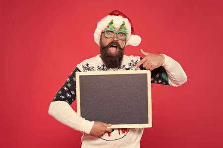 Special offer concept. Winter announcement. Bearded emotional hipster man blank blackboard copy space. Seasonal advertisement. Chalkboard information. Seasonal offer. Christmas offer. Happy hoursの写真素材