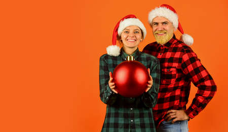 Entertainment ideas for adults. Santa team. Loving couple orange background. Christmas magical time. We love christmas. Couple in love enjoy christmas holiday celebration. Family wear santa hatsの写真素材