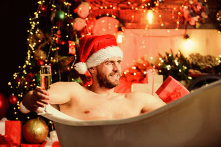 Extremely sexy. sexy mature man bath. winter holidays. happy new year gift. erotic wish. feel desire. muscular man relax bathtub. macho drink champagne after party. best xmas present. christmas spaの写真素材