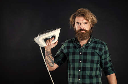 you need iron. Steaming blue iron. happy man with iron. perfect husband duty. bearded male housekeeper. hipster ironing clothes. new technology with high quality. homework and householdの写真素材