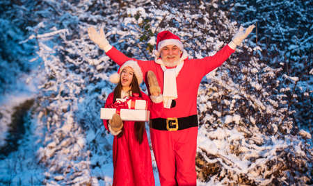 Happy childhood concept. Time for miracles. Generous Santa Claus. Child happy girl outdoors snowy nature. Merry christmas. Gifts from Santa. Frosty christmas morning. Santa and granddaughterの写真素材