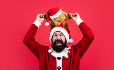 bearded santa man hold toy in hat smiling while prepare for celebrating happy new year party and christmas holiday in winter going to have xmas gifts, toy shopの写真素材