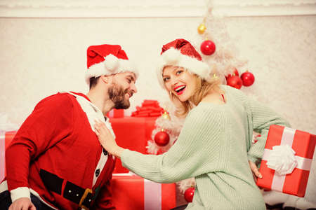 Loving couple cuddle smiling while unpacking gift christmas tree background. Family prepared christmas surprise. Opening christmas present. Couple in love happy enjoy christmas holiday celebrationの写真素材