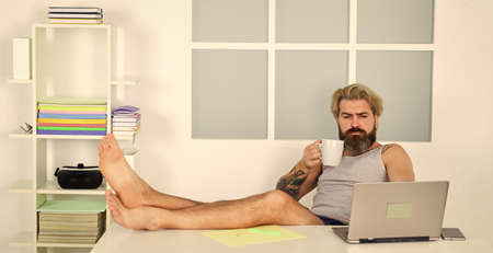 Barefoot guy working from home. Developer work computer.の写真素材