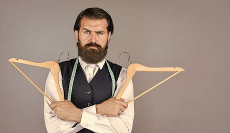 real professional. professional male sartor with measuring tape and hanger. Handsome man in smart...
