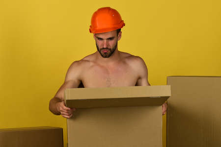 Sexuality and building concept: naked builder opening boxの写真素材
