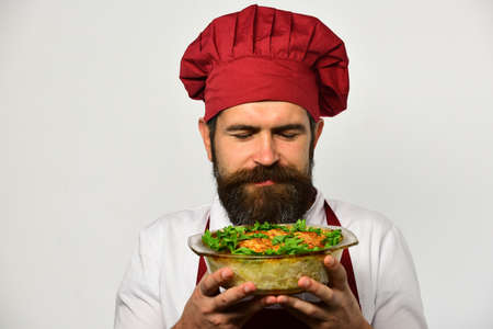 Cooking and vegetarian diet concept. Chef holds bowl with potatoの写真素材