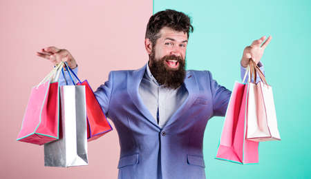 Man bearded hipster businessman formal suit carry paper shopping bags. Ready for holiday. Buy gifts...