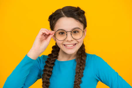 wearing uv protective. smart looking kid. beauty in glasses. childhood happiness. smiling child wear glasses because of poor eyesight. braided hair in pigtails. happy teen girl with stylish hairstyleの写真素材