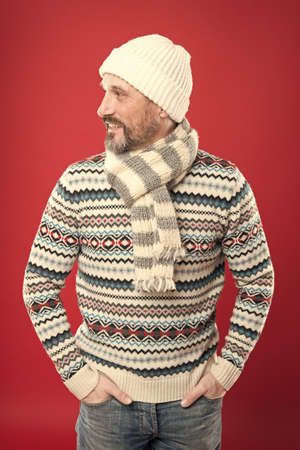Fashionable wear for chilly season. Happy man in fashionable winter style red background. Mature man...