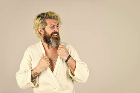 Man in bathrobe in bathroom. Hygiene and spa. Spa resort. Hotel apartments. Bearded guy wearing white bathrobe. Mature man wear bathrobe relaxing at spa. Take steps to improve your sleep habitsの写真素材