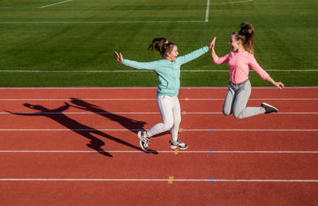 funny healthy children girls training fitness on stadium running track, sport successの写真素材