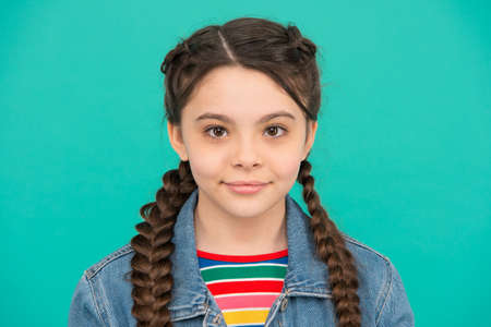 Beautiful girl child with cute look wear long hair plaits blue background, beautyの写真素材