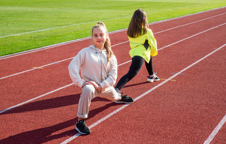 healthy children girls training fitness on stadium running track, sport