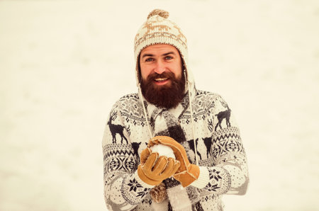 Holyday atmosphere. happy hipster play snowballs. man having fun outdoor. winter season. Christmas snow activity. winter holiday. Morning before xmas. bearded man in warm clothes. Happy new yearの写真素材