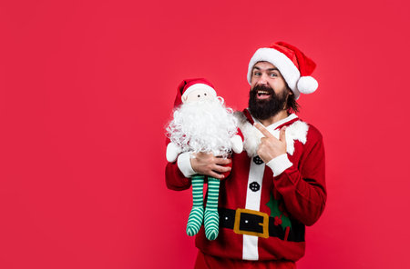Thank you. happy new year. merry christmas. cheerful bearded man in santa claus costume. hipster celebrate xmas party with toy. winter holiday preparations. present and gift shopping saleの写真素材