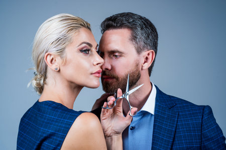 sexy couple of man and woman holding barbershop equipment, hairdresser