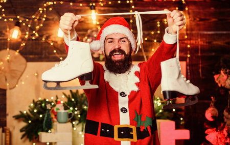 Time to celebrate. winter sport activity. winter holidays. wait for xmas presents. merry christmas. man santa hat. happy bearded man skates. new year gifts. christmas decoration. santa figure skatingの写真素材