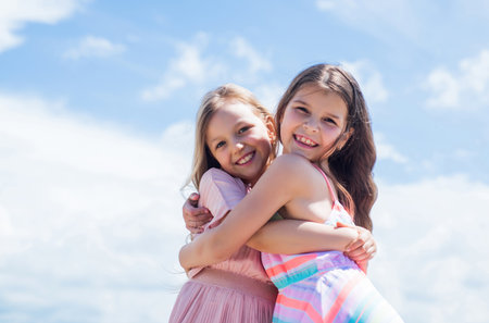 Add some action to your life. teenage girls sisters. kid fashion. cheerful family day. fashion and beauty. sisterhood or friendship concept. smiling children embrace outdoor. childhood happinessの写真素材