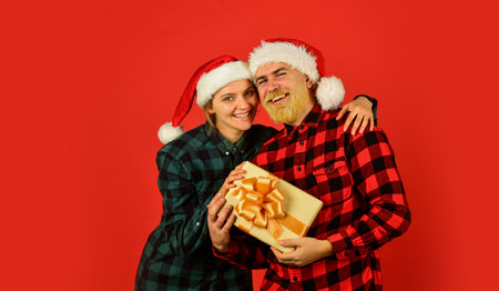 Family shopping. Surprise for spouse. Buy present. Christmas party. Christmas time. Man and woman christmas holiday celebration. Giving present. Love and care. Spread love. Couple in love with giftの写真素材